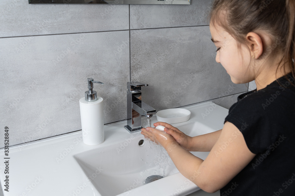 Dziewczynka myje ręce w łazience. Mycie i dezynfekcja rąk mydłem i płynem antybakteryjnym. - obrazy, fototapety, plakaty 