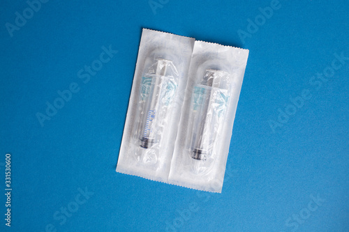 Two syringes on a blue background in a package.