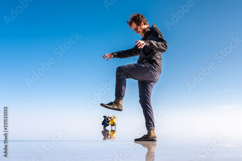 Canvas-taulu Young tourists at Uyuni Salt Flats (Spanish: Salar de Uyuni ) in Bolivia, South America, forced perspective