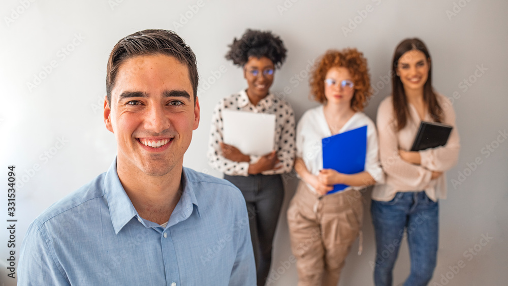 Successful company with happy employees in modern office. Cropped shot of a group of businesspeople standing in the office. Portrait of a confident businessman Successful company with happy employees in modern office. Cropped shot of a group of businesspeople standing in the office. Portrait of a confident businessman
