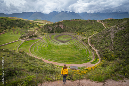 Fotografiet Female traveller at the circular Inca Terraces at Moray in the Sacred Valley of the Incas, Cusco Region, Peru