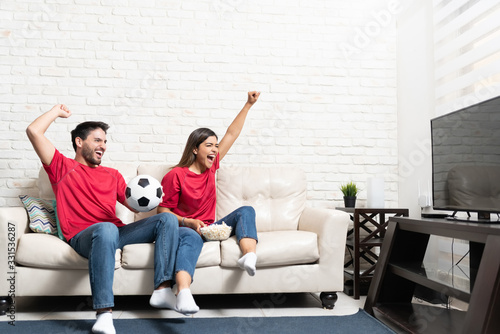 Couple Cheering While Watching Soccer Match On TV