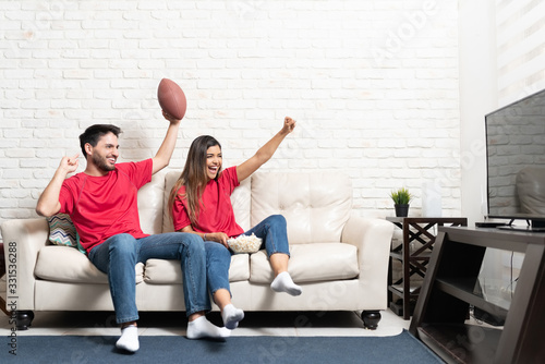 Couple Watching American Football Match On TV
