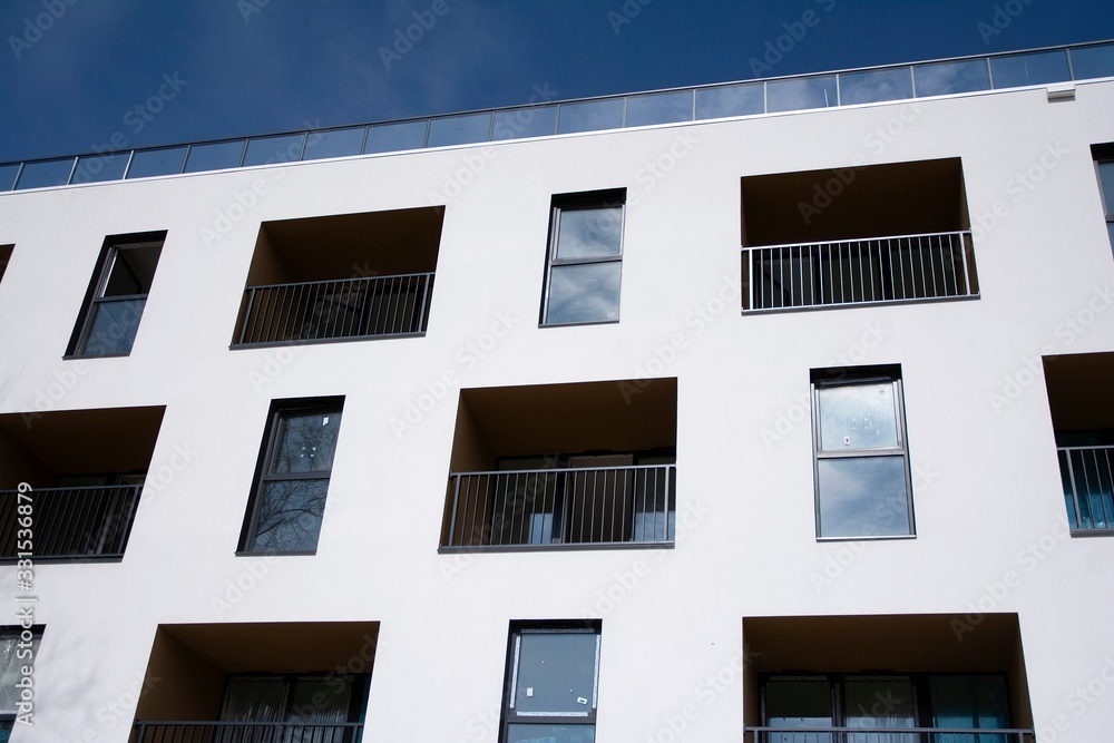 Exterior of new apartment buildings on a blue cloudy sky background. No people. Real estate business concept. Exterior of new apartment buildings on a blue cloudy sky background. No people. Real estate business concept.