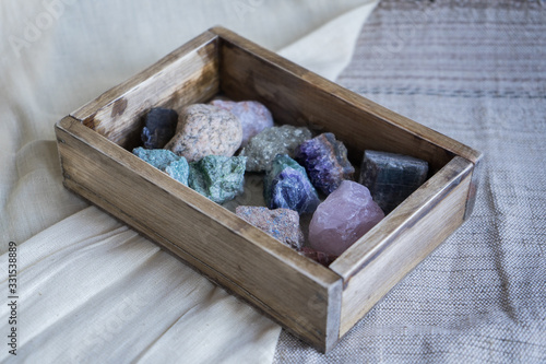 Multi-colored gems in a wooden box. Precious stones. collection of minerals photo
