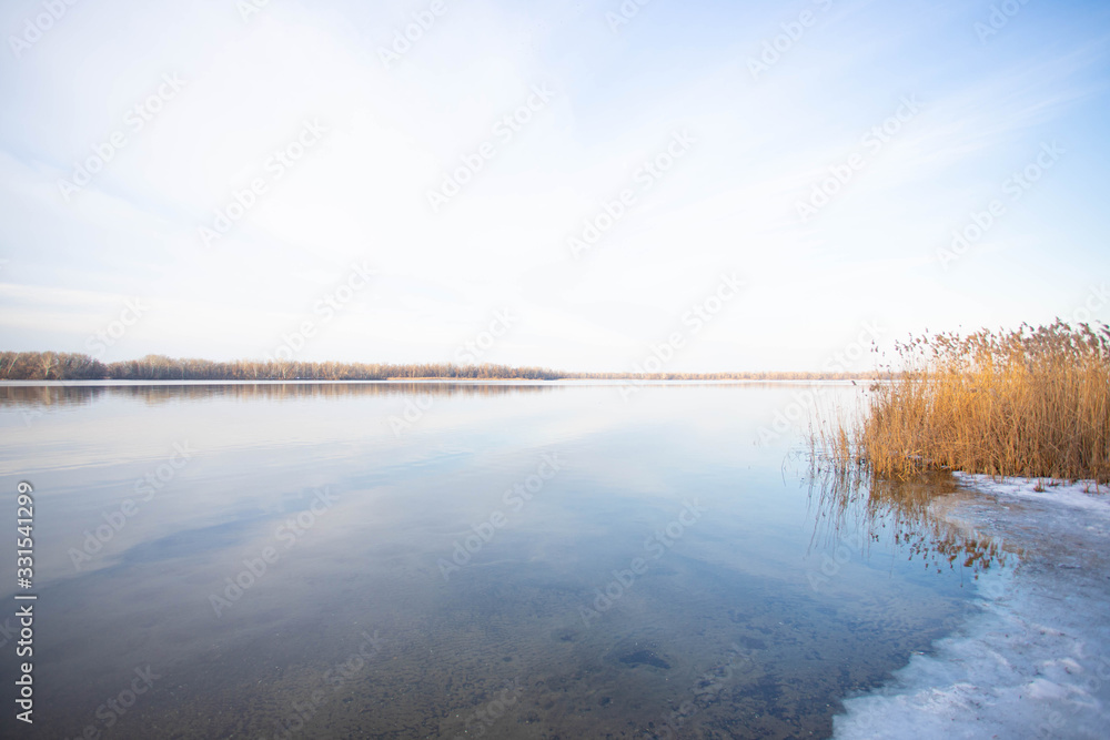 Winter river landscape. Beautiful clouds over the water. Winter river landscape. Beautiful clouds over the water.