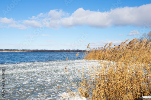 Winter river landscape. Beautiful clouds over the water