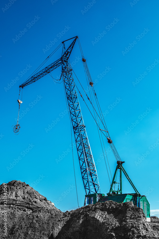 construction site with cranes on blue sky background