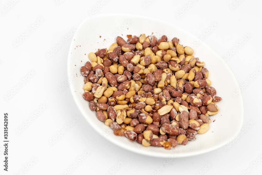 Fried Salty Peanut served in the white bowl above white background Fried Salty Peanut served in the white bowl above white background