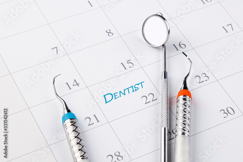 Dentist appointment in calendar with dental instruments. Dental hygienist checkup conceptual image.