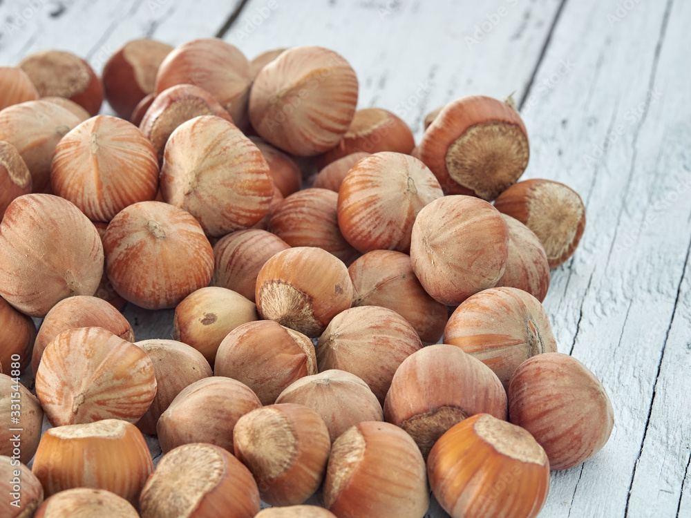 Hazelnuts lie on light wooden boards.Useful hazelnut for health. Hazelnuts lie on light wooden boards.Useful hazelnut for health.