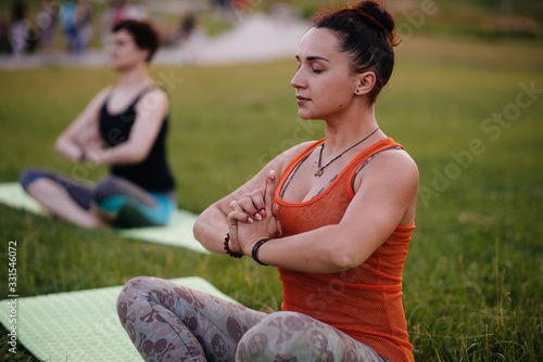 Young girls do yoga outdoors in the Park during sunset. Healthy lifestyle