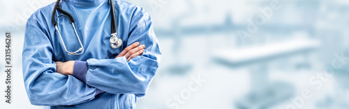 Young doctor surgeon specialist with scalpel. In the background blurred the interior of the operating room