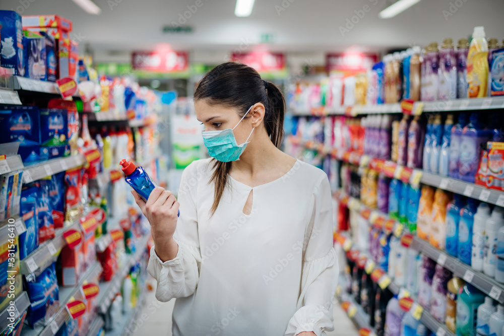 Woman wearing protective mask preparing for virus pandemic spread quarantine.Hygiene, cleaning and disinfection products.Preventive measures and protection.Supply shopping during the epidemic. Woman wearing protective mask preparing for virus pandemic spread quarantine.Hygiene, cleaning and disinfection products.Preventive measures and protection.Supply shopping during the epidemic.