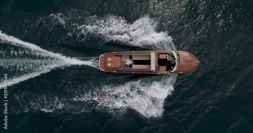 old mahogany motor boat is sailing along the beautiful Lake in Italy Aerial shot