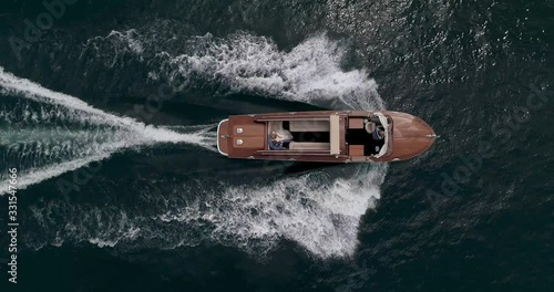 old mahogany motor boat is sailing along the beautiful Lake in Italy Aerial shot
