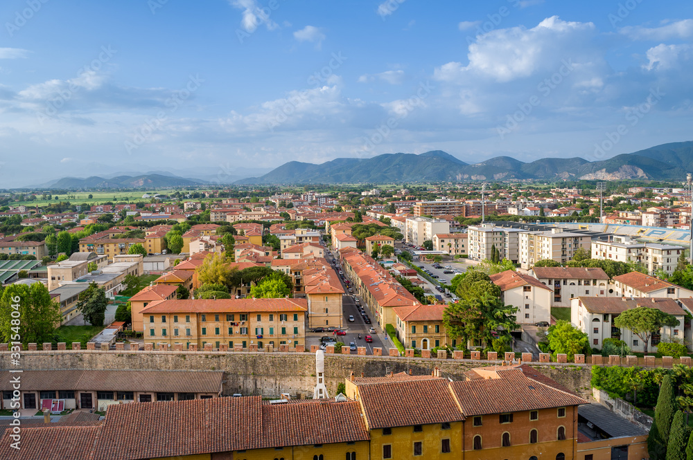 Pisa cityscape with fields and mountains at the background. Tuscany, Italy.