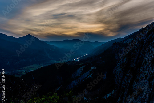 The beautiful view of the French Alps mountain range silhouette illuminated by warm sunlight during sunset
