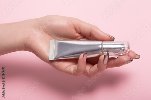 Young woman holding tube of hand cream