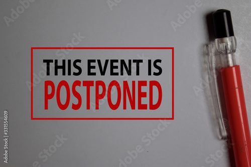 This Event is Postponed write on a book isolated on Office Desk. photo