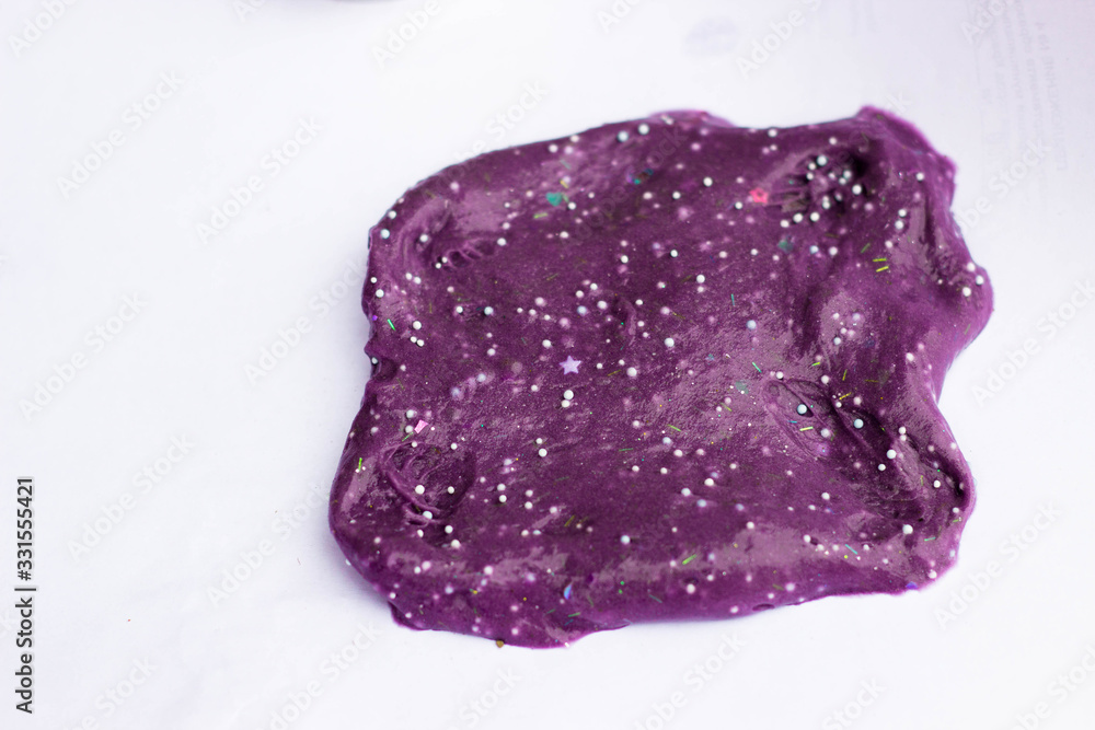 Fototapeta premium Children's creativity and motor development. Slime purple close-up on a white background in the form of a BLOB.