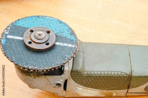 angular sanding machine with a disk for grinding on a wooden table close-up photo