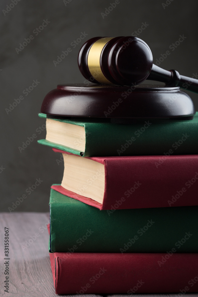 Wooden gavel and books on wooden table - law and auction concept Wooden gavel and books on wooden table - law and auction concept