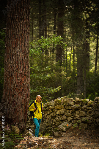 Pretty  young female hiker walking through a splendid old forest  shallow DOF 