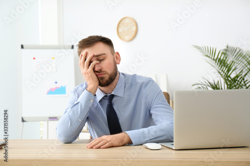 Quadro su tela Lazy young office employee procrastinating at workplace