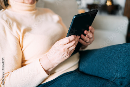 Old woman hands using a tablet. Old people with technology concept