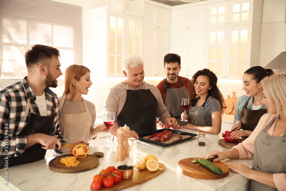 Happy people cooking food together in kitchen Happy people cooking food together in kitchen