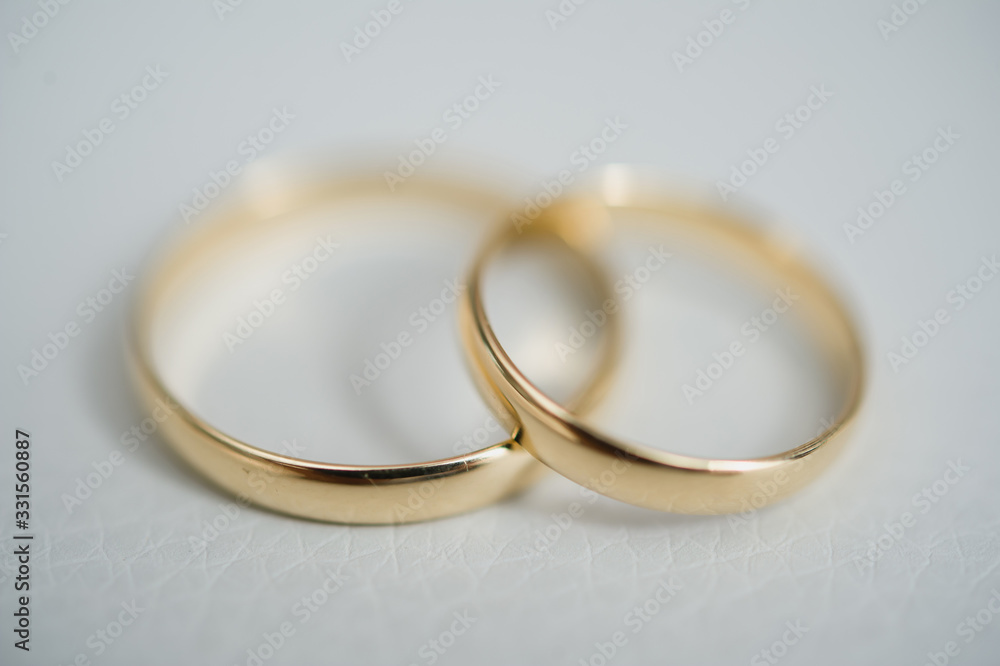 Close-up view of two golden wedding rings. Wedding symbols, attributes. Holiday, celebration. Macro. Blur Close-up view of two golden wedding rings. Wedding symbols, attributes. Holiday, celebration. Macro. Blur