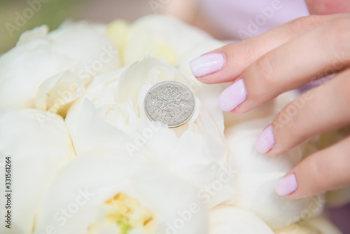 Beautiful wedding bouquet in bride s hands  wedding dress  details. The girl in a pink dress holding a bouquet of white  blue  pink flowers and greenery  decorated with silk ribbon