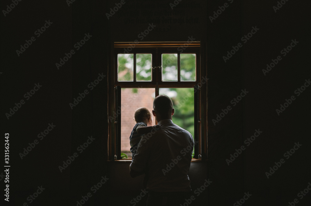 Vater und Kind schauen aus dem Fenster