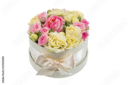 Fresh, lush bouquet of colorful flowers for present isolated on white background. Wedding bouquet of pink and yellow roses in the beige round gift box © Georgiy