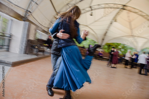 Romantic young couple walking and dancing in the park. Teenagers on a date. The guy and the girl are whirling in the dance. Love and romance. The first relationship. City life