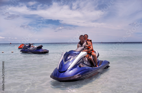 Happy couple of caucasian tourists visiting Thailand seating on a jet water ski © jovannig