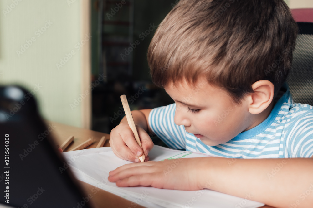 Litle child siting at desk and drawing letters album with colored pencils, lifestyle Litle child siting at desk and drawing letters album with colored pencils, lifestyle