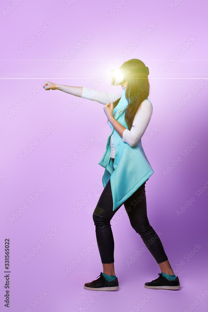 Fototapeta premium Woman is using virtual reality headset, playing game and fighting.