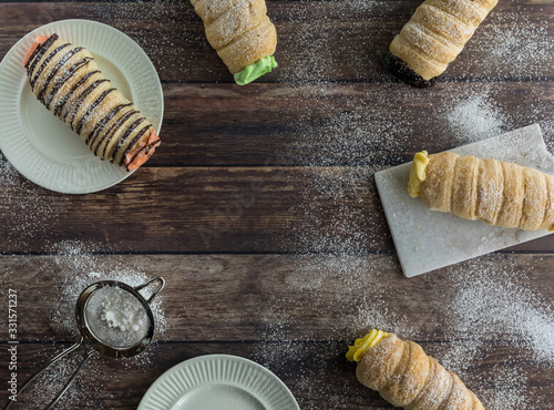 Top down view of several cannoli covered in powdered sugar with copy space in the middle. photo