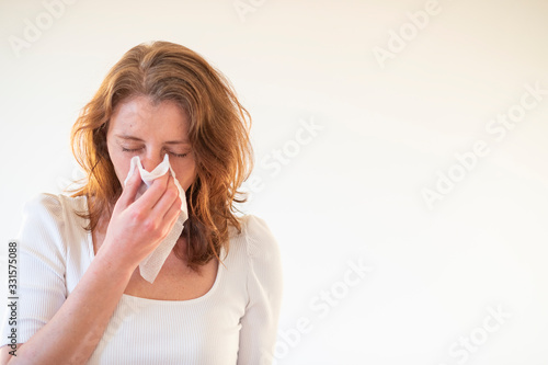 woman blowing her nose in a tissue