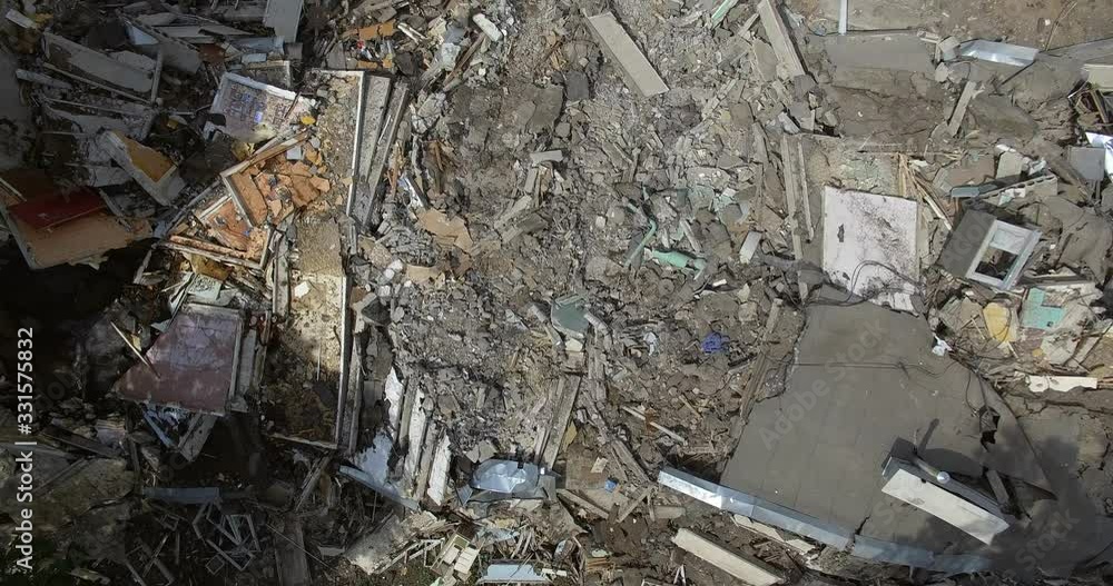 Flying up from a debris heap to a general view of a partly demolished residental building Flying up from a debris heap to a general view of a partly demolished residental building