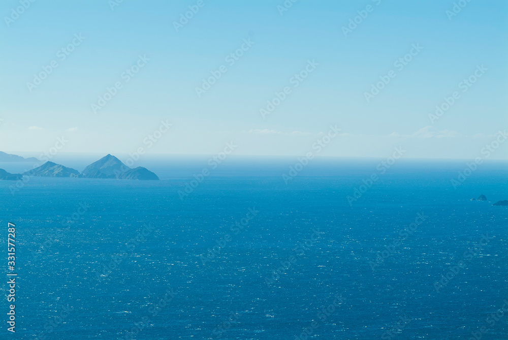 Blue islands in the ocean. French Pass, New Zealand. Top view to blue horizon, ocean view and small rocky islands