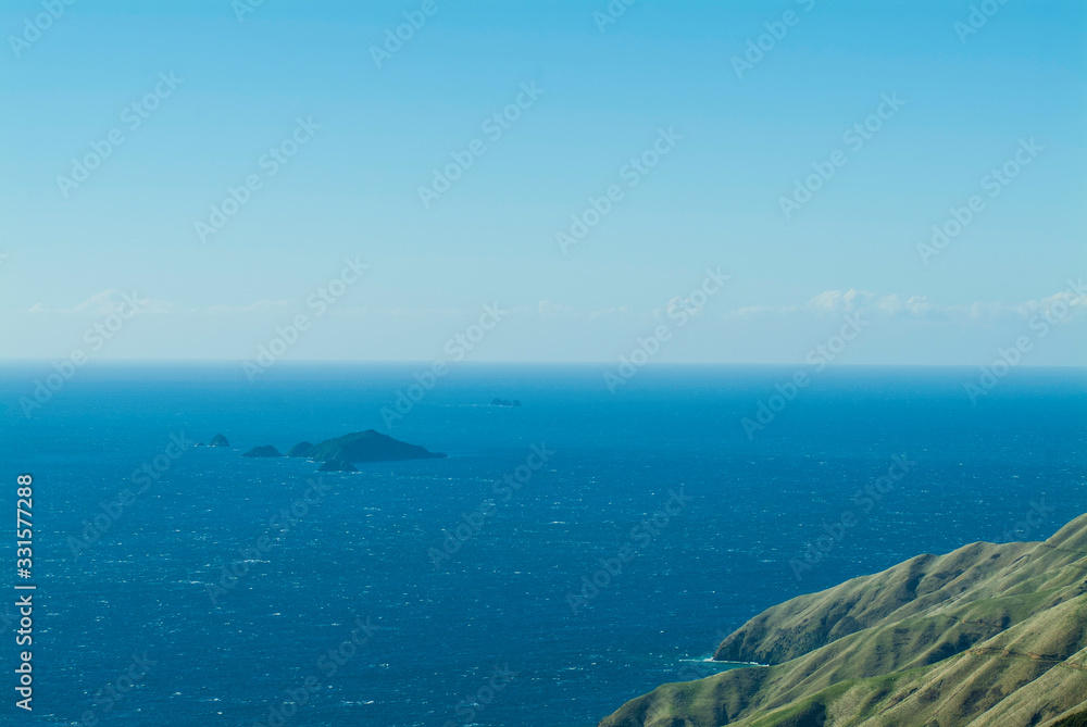 Blue islands in the ocean. French Pass, New Zealand. Top view to blue horizon, ocean view and small rocky islands