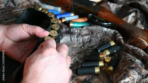 The hunter is going to hunt, puts ammunition in a bandoleer.