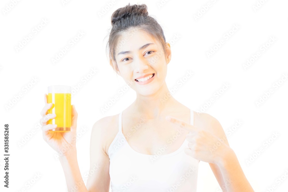 Young beautiful asian woman wearing a white tank top, holding a glass of orange juice and drinking happily anddeliciously ,isolated on background,Health care concept Young beautiful asian woman wearing a white tank top, holding a glass of orange juice and drinking happily anddeliciously ,isolated on background,Health care concept