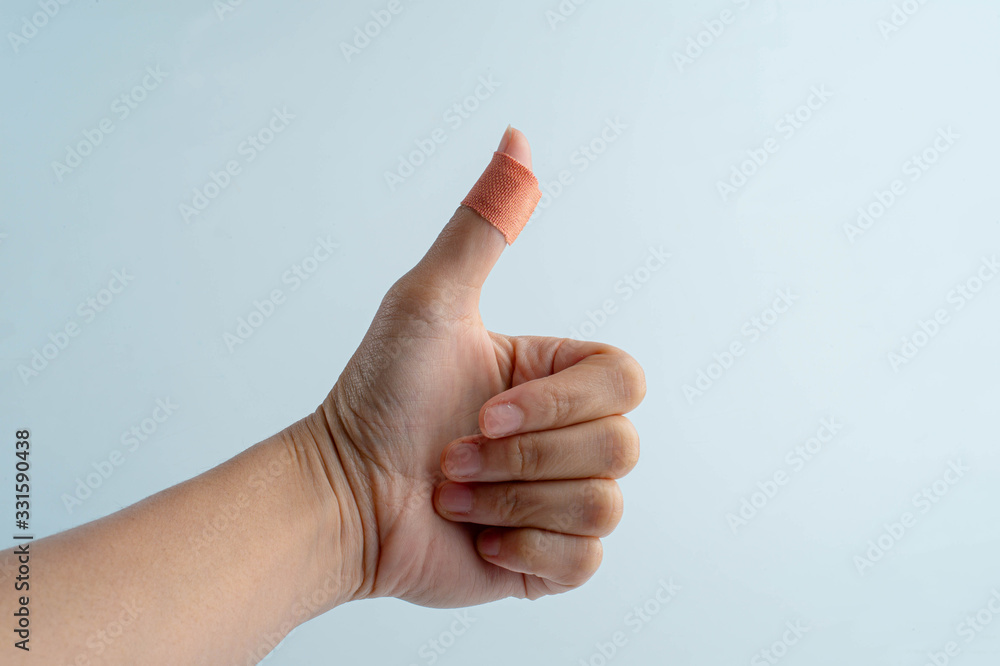 A bandage on the thumb. Isolated on white with clipping path. A bandage on the thumb. Isolated on white with clipping path.