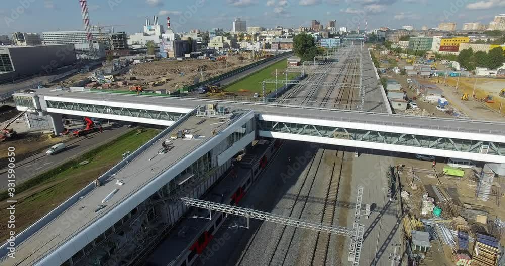Aerial view of a suburban area with a flat bridge over railways and a moving train Aerial view of a suburban area with a flat bridge over railways and a moving train