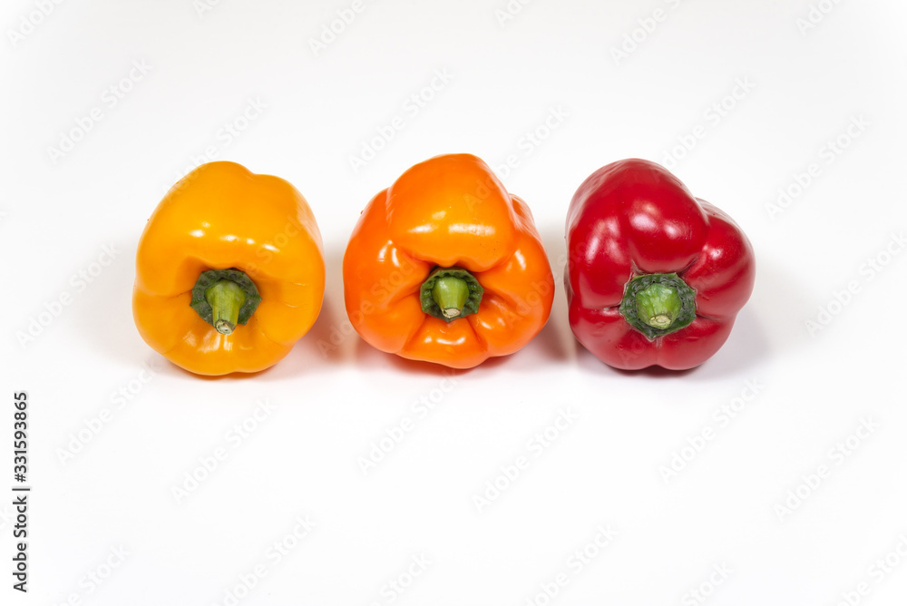 Sweet peppers yellow, orange, red on white background, top view Sweet peppers yellow, orange, red on white background, top view