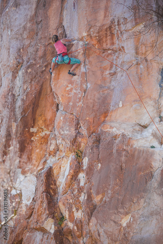A girl climbs a rock.